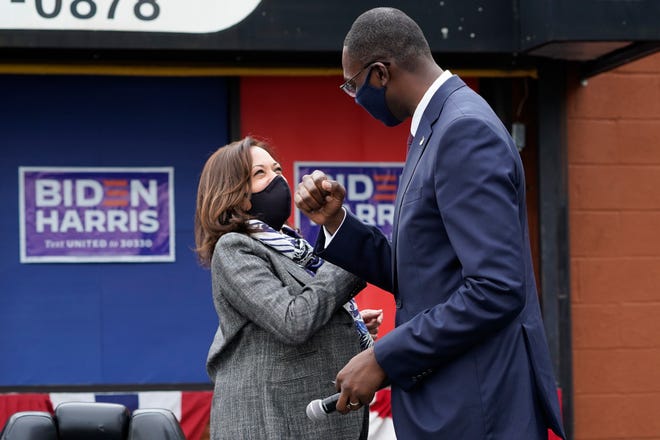 Democratic vice presidential candidate Sen. Kamala Harris, D-Calif., and Michigan Lt. Gov. Garlin Gilchrist II greet one another at Headliners Barbershop in Detroit, Tuesday.