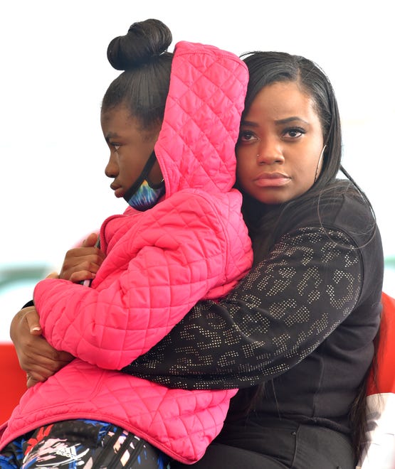 Tai'raz Moore's mother, Brittany Thompson, holds onto her daughter, Madison Harris, Tai'raz's sister, during the public memorial.