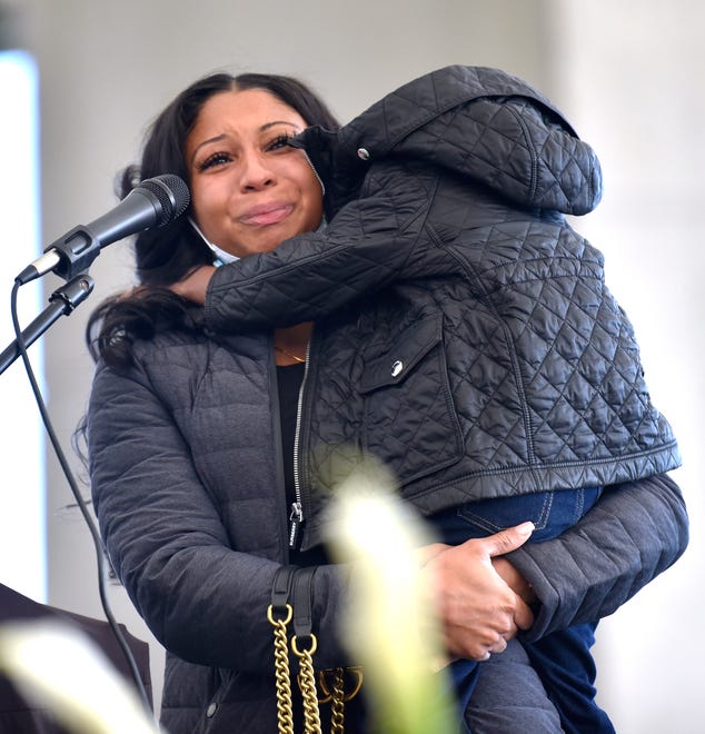 Jayla Jones, aunt to Tai'raz, starts to cry while sharing memories of her nephew as her son, Elijah Juan Logan Jones, 3, climbs onto the stage to comfort his distraught mother who cannot continue talking at the mic.