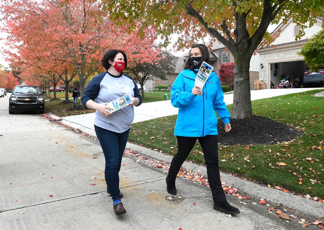 Michigan Governor Gretchen Whitmer and Julia Pulver, Candidate for 39th House District walk to the another house down the street while campaigning in West Bloomfield Township, Michigan on October 18, 2020.