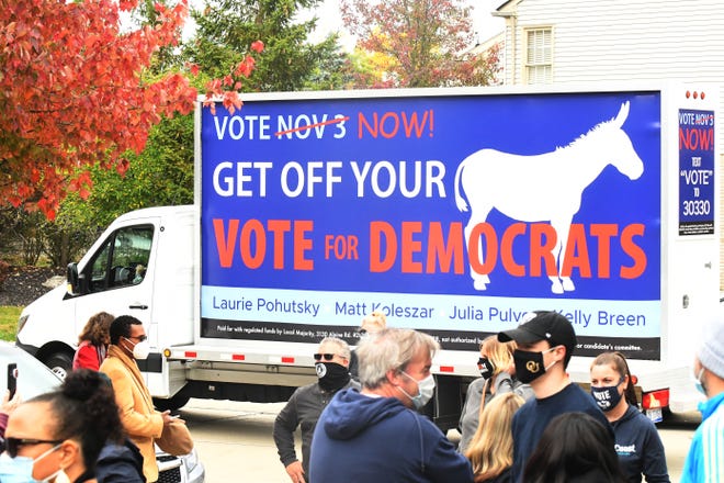 A trailer passes by with a pro-Democrat message, during a press conference with Michigan Governor Gretchen Whitmer, Julia Pulver, Candidate for 39th House District and Debbie Dingell, U. S Representative for Michigan's 12th District, in West Bloomfield Township, Michigan on October 18, 2020.