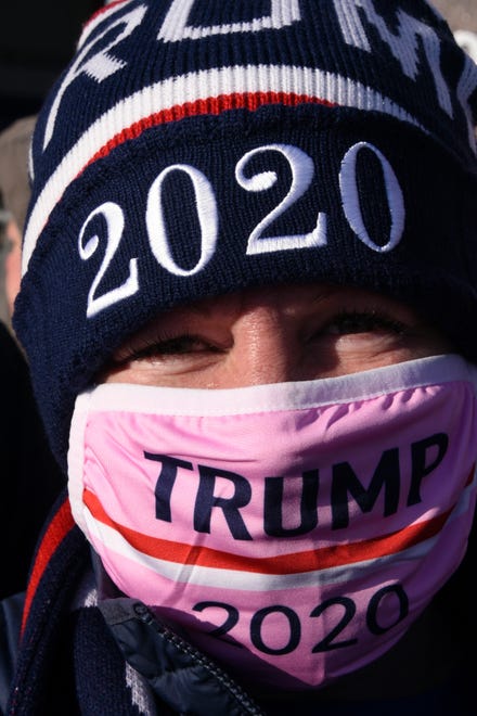 A supporter waits for President Donald Trump at a campaign rally in Traverse City, Mich. Monday, Nov. 2, 2020.