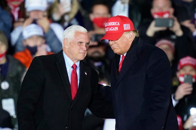 President Donald Trump, right, talks with Vice President Mike Pence as they arrive for a campaign rally Monday, Nov. 2, 2020, in Grand Rapids, Mich.