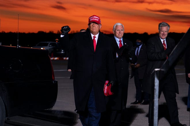 President Donald Trump and Vice President Mike Pence arrive for a campaign rally at Cherry Capital Airport, Monday, Nov. 2, 2020, in Traverse City, Mich. At right is White House chief of staff Mark Meadows.