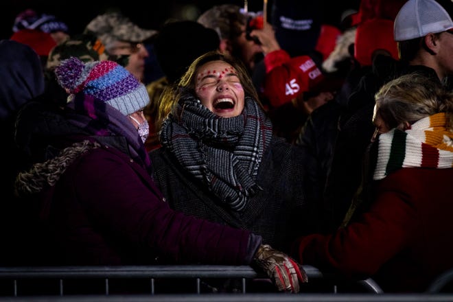 Summer Burkhardt of Flint (center) shares a laugh with her sister, Elizabeth (left) and mom Nancy (right) before President Donald Trump delivers remarks at his fifth and final rally of the day—and the campaign—at Gerald R. Ford Airport in Grand Rapids, Michigan on November 2, 2020.  The rally started at midnight and went into election day.
