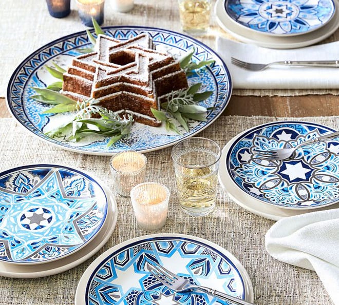 Hanukkah-themed stoneware features an interpretation of the Star of David in classic palette of blue and white. Inspiration for the motifs is from vintage mosaics. The plates feature glazed decal finish. The platter is 16 1/4 inches in diameter; salad plates are 9 inches. The Ramie metallic runners (108 inches) add a whisper of sparkle. All from Pottery Barn.