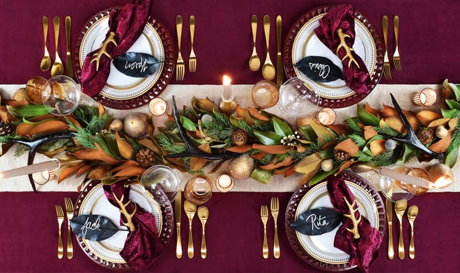 A 6-foot long garland of magnolia mixed with greens, tallow berries and pine cones is the center piece of this holiday table from Hestia Harlow. The Twist on Tradition theme, designed by Marielle Shortell, is available for rent. Each rental setting of four includes cranberry stud charger plate, Harlow gold-framed dinner plate, Caroline gold-lined salad plate, Winifred coupe cocktail glass, Natalya glass tumbler, Priscilla classic gold flatware (5 piece), sparkle table runner, crushed velvet napkins, gilded antler napkin rings and unscented votive candles.