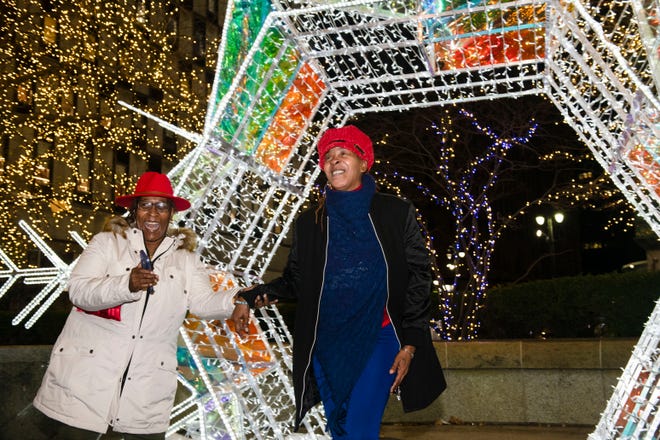 Earlene Ward, left, and her sister Annette Eppinger share a laugh on Eppinger's 55th birthday while taking in the holiday lights displays at Campus Martius Park Friday night in Detroit.