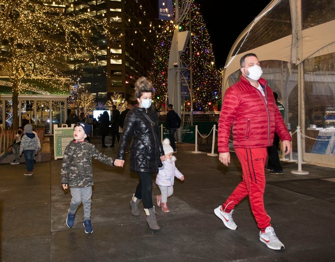 Eddie and Denisa Bregu of Detroit stroll among the holiday lights with their children John, 5, and Chloe, 2, in Campus Martius Park in Detroit Friday night.