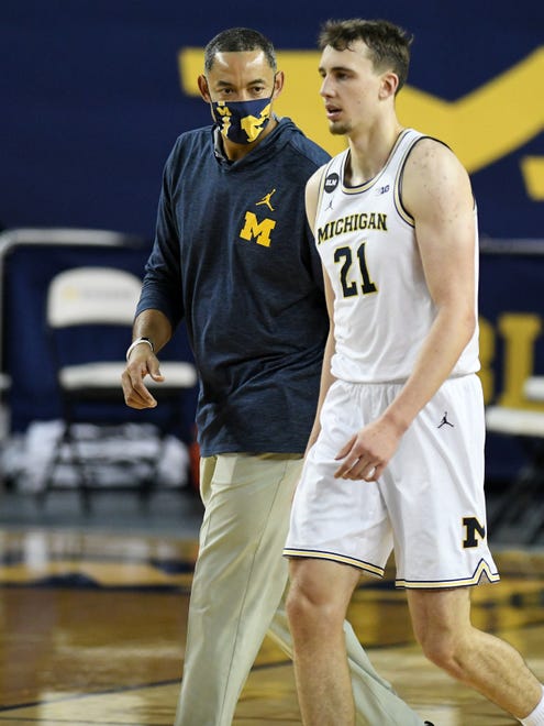 Michigan head coach Juwan Howard talks with Michigan guard Franz Wagner (21) as they exit the court after Wagner is in pain (he returned to the game) in the second half.  Michigan vs Ball State at Crisler Center in Ann Arbor, Mich. on Dec. 2, 2020.  Michigan wins, 84-65.