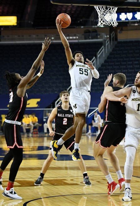 Michigan guard Eli Brooks (55) puts up a basket between Ball State's Kani Acree, left, Luke Bumbalough (2) and Blake Huggins, right, in the first half.