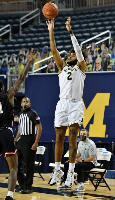 Michigan forward Isaiah Livers (2) shoots over Ball State guard K.J. Walton (1) in the first half.