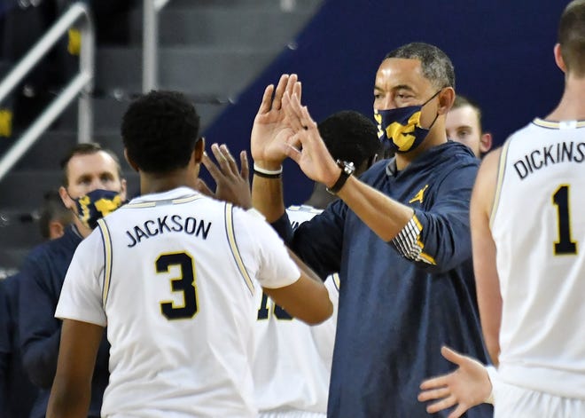 Michigan head coach Juwan Howard greets the team including Michigan guard Zeb Jackson (3) at a time out in the first half.
