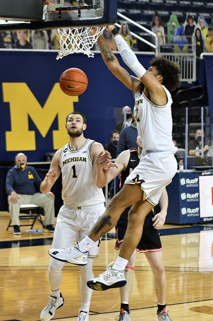Michigan forward Isaiah Livers (2) dunks in front of Ball State center Ben Hendriks (34) and Michigan center Hunter Dickinson (1) in the second half.  Michigan vs Ball State at Crisler Center in Ann Arbor, Mich. on Dec. 2, 2020.  Michigan wins, 84-65.