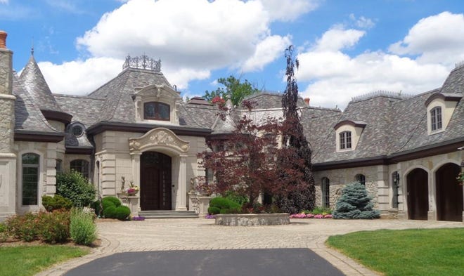KW Domain Luxury Realty lists this five-bedroom, seven full bath, two half bath Tudor-style home at 5339 Trillium Court in Orchard Lake Village for $5,100,000. The three-story residence, built in 2003, is on 1.63 acres with an 8-10 car garage situated on Upper Straits Lake in the Trillium Bluff subdivision.
