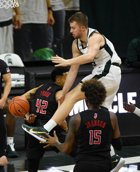 Michigan State's Thomas Kithier works above the Rutgers' Myles Johnson (15) and Jacob Young during the first half.