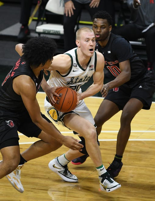 Michigan State's Joey Hauser drives between Rutgers' Ron Harper Jr. and Montez Mathis (10) in the first half.