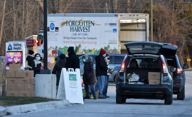 Volunteers put food for families into vehicles at the Forgotten Harvest mobile food pantry at the Sterling Heights Community Center in Sterling Heights, Mich. on Jan. 7, 2021. Based on the turnout Forgotten Harvest will evaluate their schedule but may continue every Thursday in Sterling Heights. The information will be on their website.