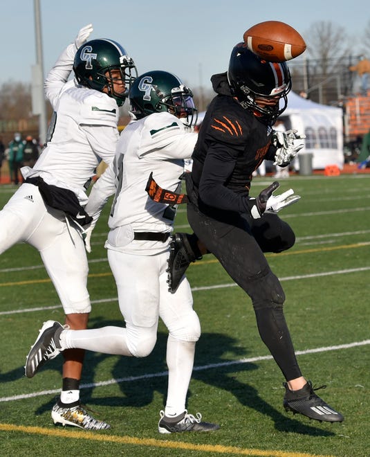 Belleville's Darrell Johnson (9) can't find the handle on this pass that's broken up by Cass Tech's Miles Gilmore (21) and Jameel Gardner (9) in the fourth quarter.