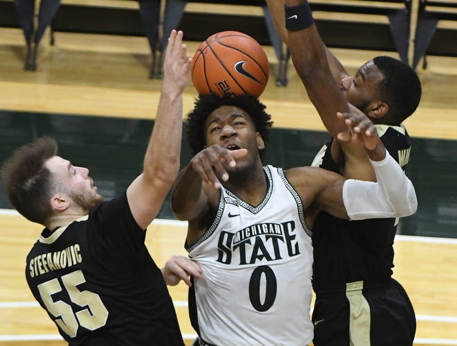 Michigan State's Aaron Henry shot is put back on his head by Purdue's Sasha Stefanovic and Aaron Wheeler in the second half.