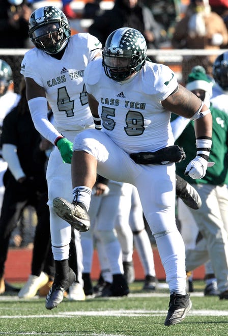 Cass Tech's Clarence Wilson (44) and Jarvis Windom (58) celebrate a fumble recovery at the end of the second quarter.