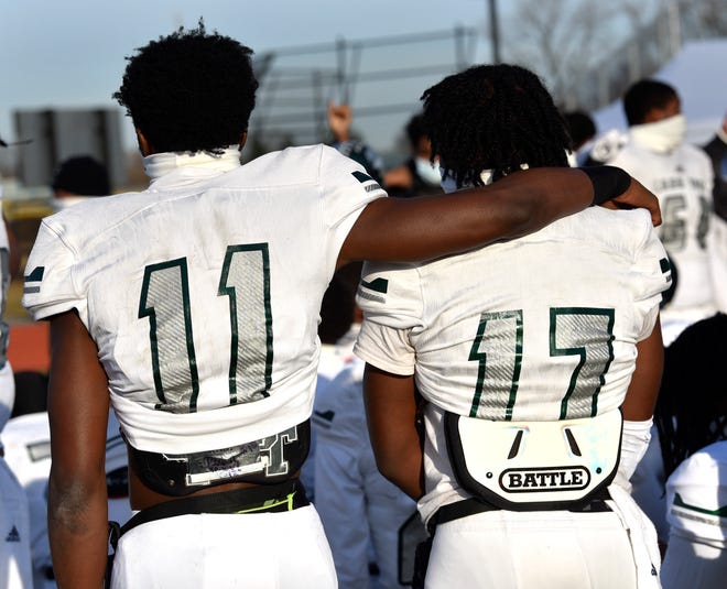 Detroit Cass Tech players Joel Graves (11) and Brent Parker (17) console each other after their loss to Belleville.