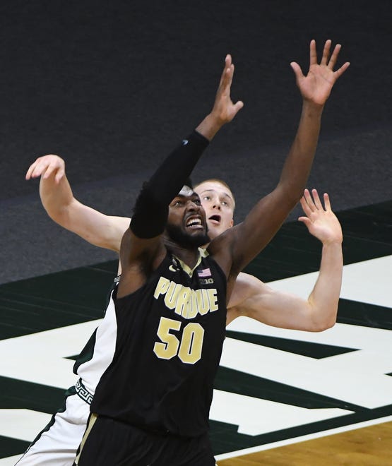 Purdue's Trevion Williams and Michigan State's Joey Hauser look for a rebound in the second half.