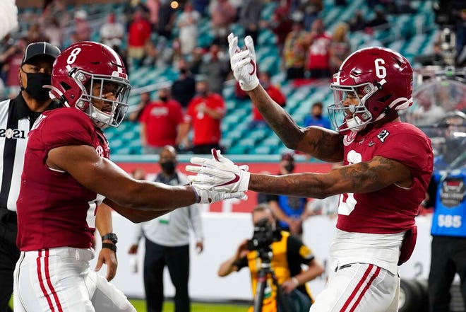 Alabama wide receiver John Metchie III, left, congratulates wide receiver DeVonta Smith, after Smith scored a touchdown against Ohio State during the first half.