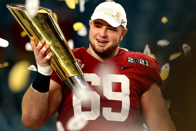 Landon Dickerson (69) of the Alabama Crimson Tide holds the trophy following the College Football Playoff National Championship game win over the Ohio State Buckeyes at Hard Rock Stadium on January 11, 2021.