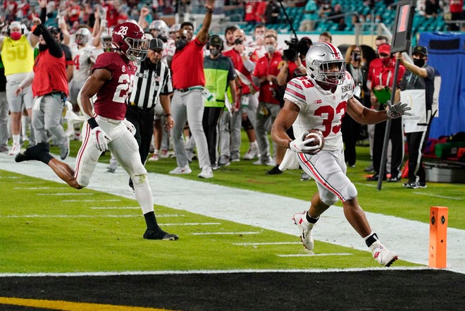 Ohio State running back Master Teague III scores a touchdown past Alabama defensive back Josh Jobe during the first half.