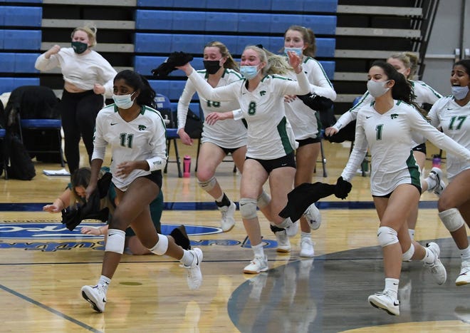 Novi's players race out onto the court after beating Ann Arbor Skyline in 5 games.