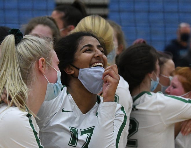 Novi's Megha Gondi's smile breaks through as she adjusts her mask after beating Ann Arbor Skyline in five games in the volleyball quarterfinals at Lincoln High School in Ypsilanti, Michigan  on January 12, 2021.