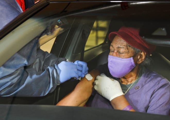 Nurse Jeffrey Suhre gives Mamie Cokley, 85 of Detroit her COVID-19 vaccination at a drive-thru vaccination effort in the basement of the TCF Center in Detroit on Wednesday.