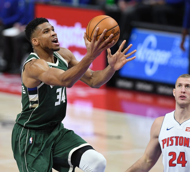 Bucks' Giannis Antetokounmpo scores over the Pistons' Mason Plumlee in the fourth quarter. Antetokounmpo had a triple double, 22 points, 10 rebounds and 10 assists.