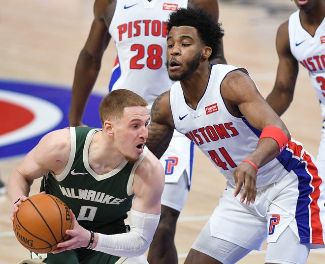 Buicks' Donte DiVincenzo drives around Pistons' Saddiq Bey in the fourth quarter.
