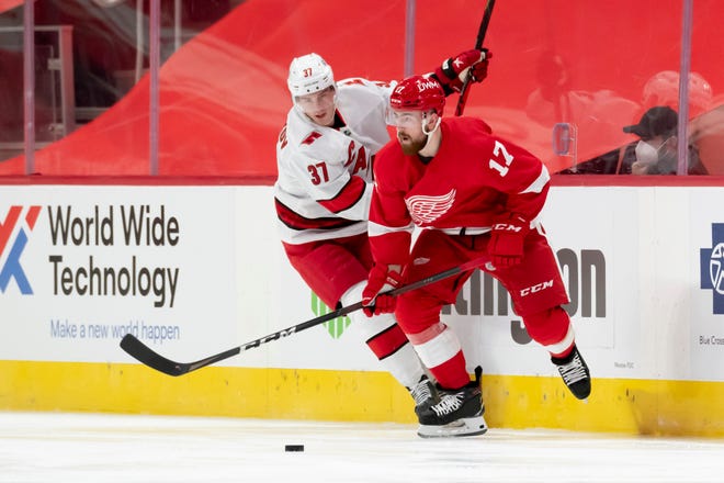 Detroit defenseman Filip Hronek keeps the puck away from Carolina right wing Andrei Svechnikov in the second period during a game between the Detroit Red Wings and the Carolina Hurricanes, at Little Caesars Arena, in Detroit, January 14, 2021.