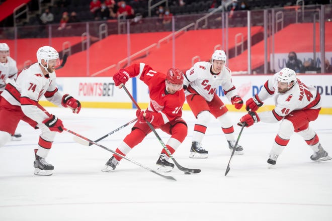 Detroit right wing Filip Zadina tries to slip through the Carolina defense in the first period during a game between the Detroit Red Wings and the Carolina Hurricanes, at Little Caesars Arena, in Detroit, January 14, 2021.