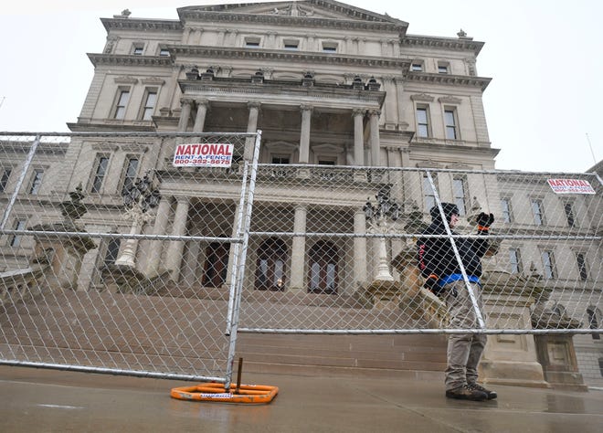 Dakota Pitz, of National Construction Rentals, puts up fencing around the Michigan State Capitol in preparation for possible protests over the weekend in Lansing, Michigan  on January 15, 2021.
