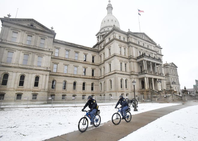 Michigan State Police officers patrol around the Michigan State Capital Friday morning on bicycle in Lansing, Michigan  on January 15, 2021.