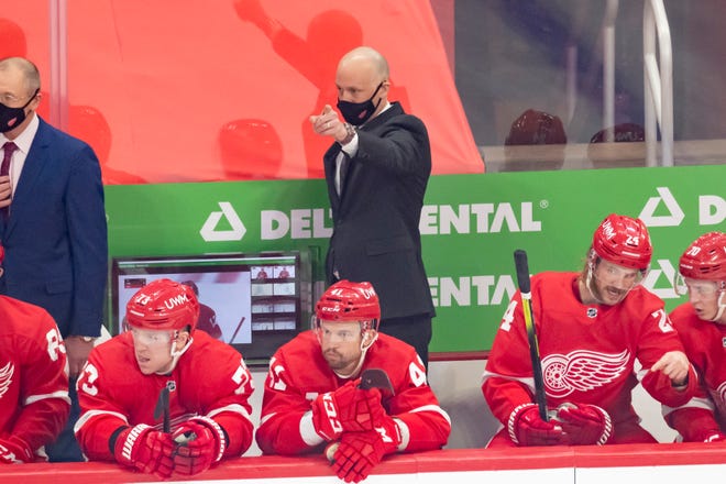 Detroit head coach Jeff Blashill, center, calls out to his players in the first period during a game between the Detroit Red Wings and the Carolina Hurricanes, at Little Caesars Arena, in Detroit, January 14, 2021.