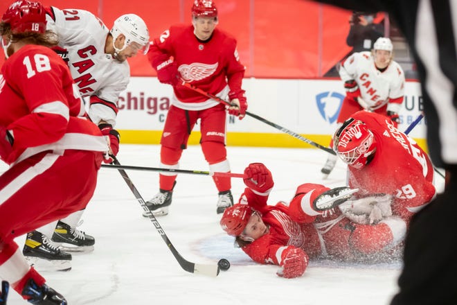 Detroit right wing Troy Stecher collides with goaltender Thomas Greiss as Carolina right wing Nino Niederreiter tries to score in the second period during a game between the Detroit Red Wings and the Carolina Hurricanes, at Little Caesars Arena, in Detroit, January 14, 2021.
