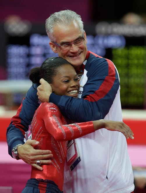 U.S. head coach John Geddert hugs gymnast Gabrielle Douglas after her performance during the Artistic Gymnastics women's team final at the 2012 Summer Olympics, Tuesday, July 31, 2012, in London.