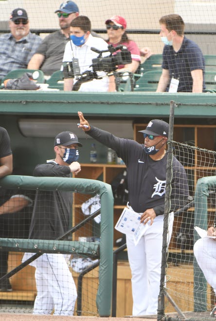 Tigers first base coach Ramon Santiago gives instructions from the dugout in the fourth inning.