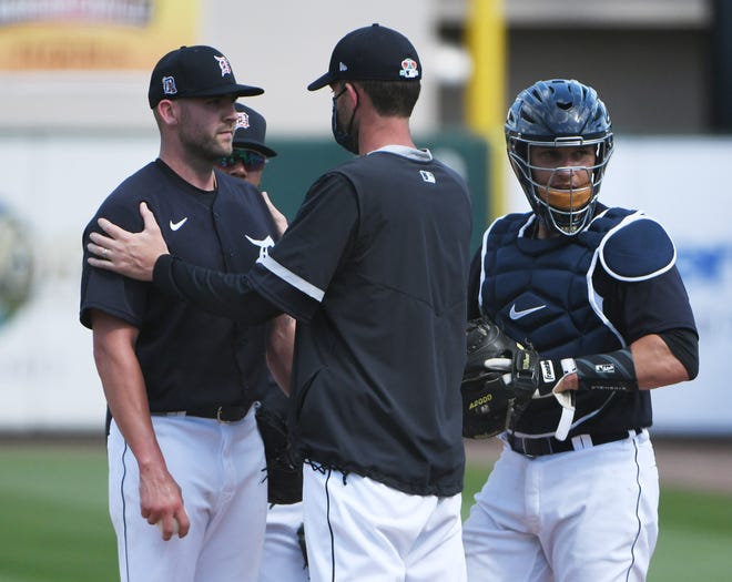 Tigers pitching coach Chris Fetter, center, talks with pitcher Alex Lange, left, with non-roster catcher Brady Policelli in the fourth inning.