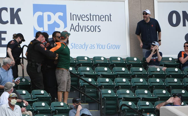 A fan has a few words for an unruly fan being removed by Lakeland police officers in the seventh inning of a seven-inning game.  Detroit Tigers vs Philadelphia Phillies at Joker Marchant Stadium in Lakeland, Fla. on Feb. 28, 2021.  Tigers win, 10-2.