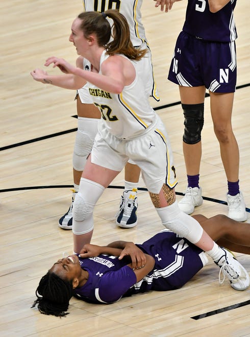 Michigan guard Leigha Brown (32) stands over Northwestern forward Courtney Shaw (15) after Brown is called for a charge in the second half.