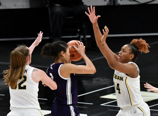 Michigan's Leigha Brown (32) and Akienreh Johnson (14) guard Northwestern guard Sydney Wood (3) in the second half.