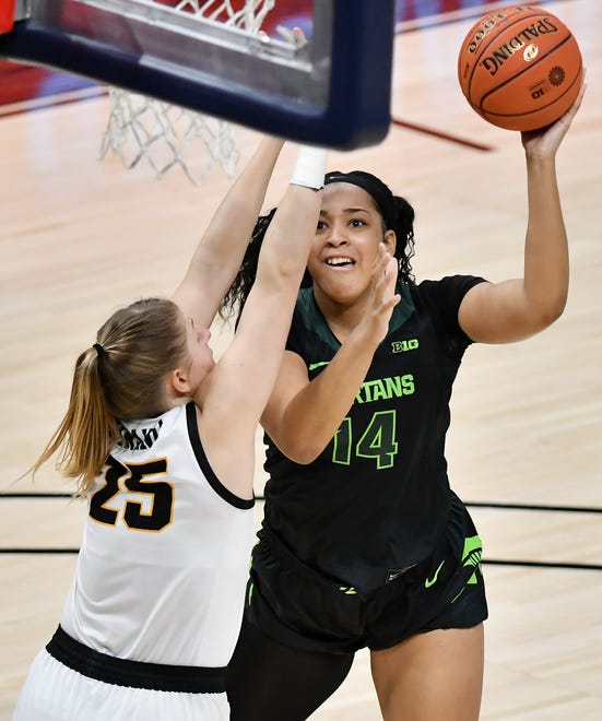 Michigan State forward Taiyier Parks (14) puts up a shot over Iowa forward Monika Czinano (25) in the first half.