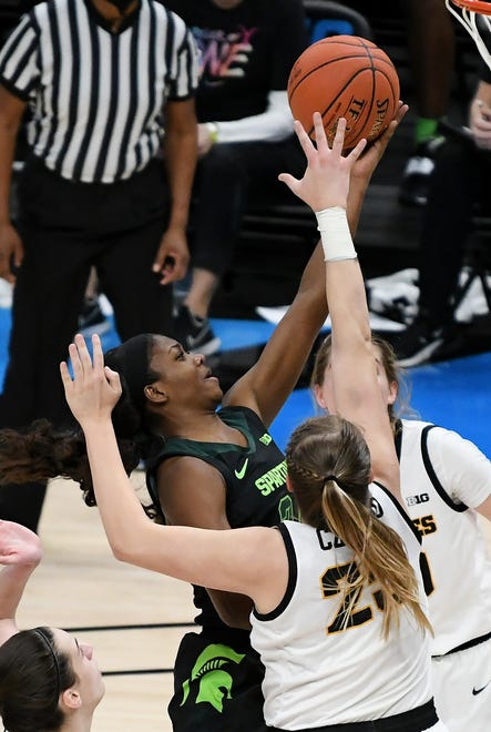 Michigan State guard Nia Clouden (24) drives to the basket with Iowa forward Monika Czinano (25) defending in the second half.