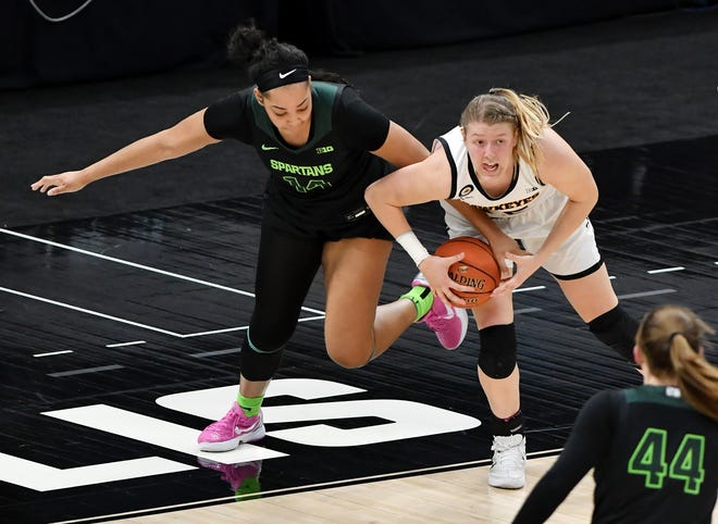 Michigan State forward Taiyier Parks (14) tangles up with Iowa forward Monika Czinano (25) in the second half.